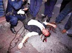 Polizisten umringen einen verletzten Demonstranten.(Archiv)