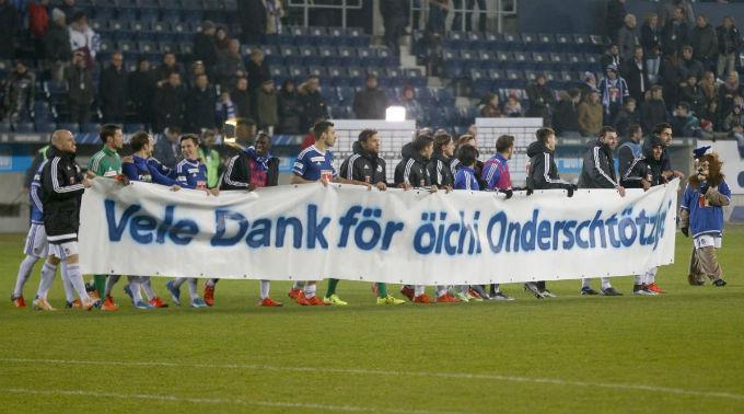Die FC Luzern Spieler bedanken sich nach dem Spiel mit einem Transparent bei den Fans.